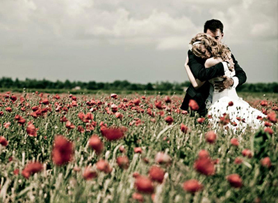 Bride and groom in a poppy field